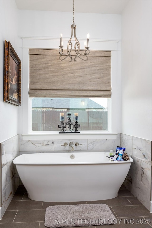 full bath with a wainscoted wall, tile patterned floors, and tile walls