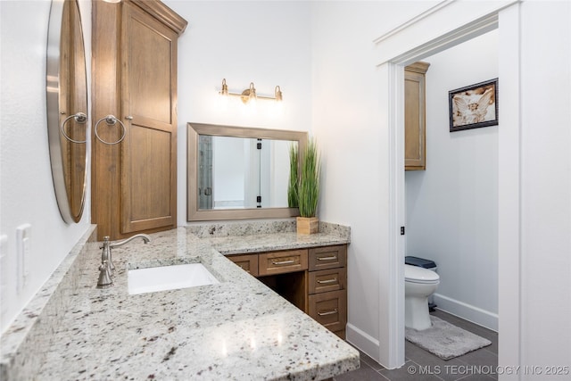 bathroom featuring baseboards, toilet, vanity, and tile patterned floors