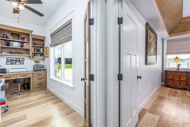 office area featuring baseboards, a ceiling fan, and light wood finished floors