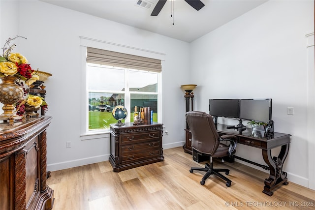office space with baseboards, a ceiling fan, visible vents, and light wood-style floors