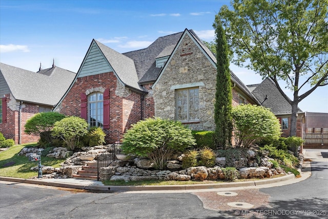 10135 S 78th E Ave, Tulsa, OK 74133 - tudor home featuring roof with shingles, brick siding, and stone siding