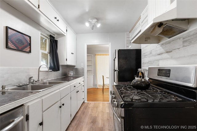 kitchen featuring a sink, white cabinetry, decorative backsplash, under cabinet range hood, and appliances with stainless steel finishes