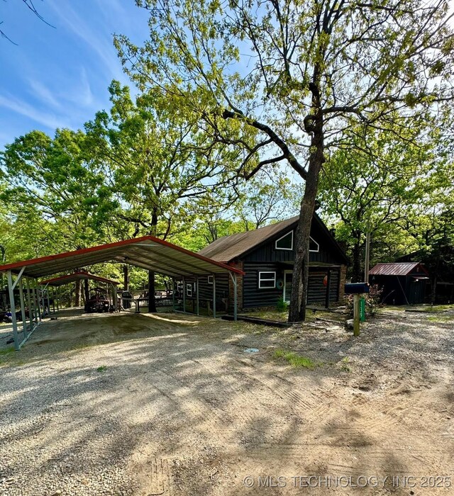 139 N Bk 1800 Rd, Stigler, OK 74462 - view of front of house featuring a detached carport, board and batten siding, and dirt driveway