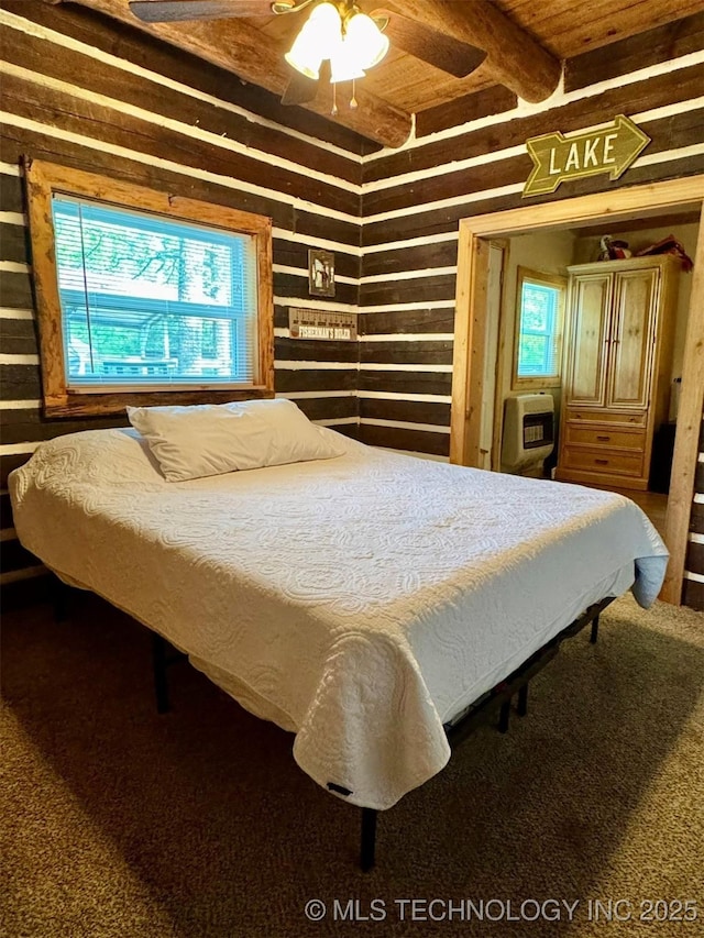 139 N Bk 1800 Rd, Stigler, OK 74462 - bedroom with heating unit, carpet flooring, beamed ceiling, a ceiling fan, and wood walls