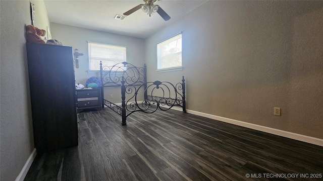 506 S Delaware Ave, Okmulgee, OK 74447 - bedroom featuring baseboards, a ceiling fan, visible vents, and dark wood-style flooring