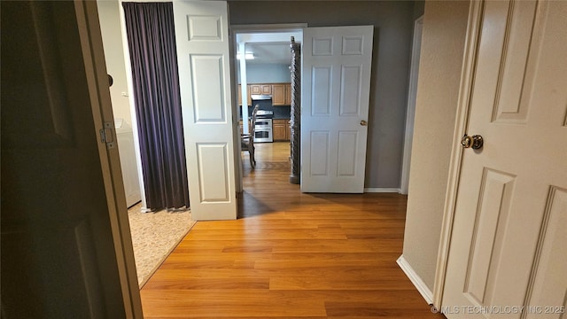 506 S Delaware Ave, Okmulgee, OK 74447 - corridor featuring light wood-style flooring and baseboards