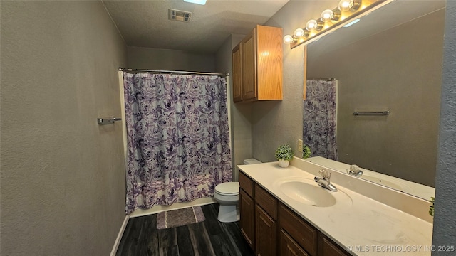 506 S Delaware Ave, Okmulgee, OK 74447 - bathroom with toilet, visible vents, wood finished floors, a shower with shower curtain, and vanity