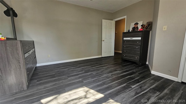 506 S Delaware Ave, Okmulgee, OK 74447 - unfurnished bedroom with baseboards and dark wood finished floors