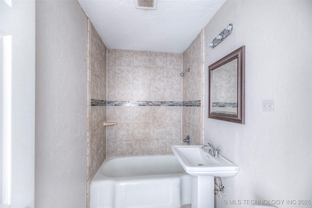 bathroom with tub / shower combination, visible vents, and a sink