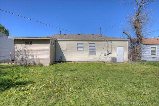 rear view of house featuring a lawn, fence, and central air condition unit