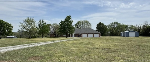 view of yard featuring driveway and an outdoor structure