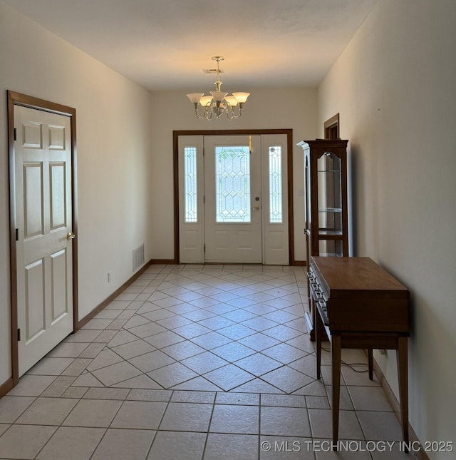 entrance foyer featuring light tile patterned flooring, visible vents, baseboards, and an inviting chandelier