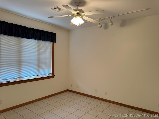 spare room with baseboards, a ceiling fan, visible vents, and light tile patterned floors
