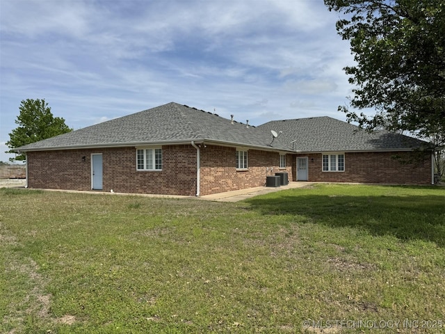 402325 W 2100th Rd, Bartlesville, OK 74006 - rear view of property featuring cooling unit, a lawn, brick siding, a shingled roof, and a patio area