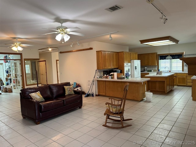 living room with rail lighting, a ceiling fan, light tile patterned floors, and visible vents
