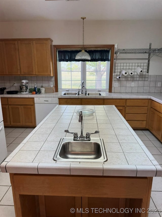 kitchen with dishwasher, a sink, and backsplash
