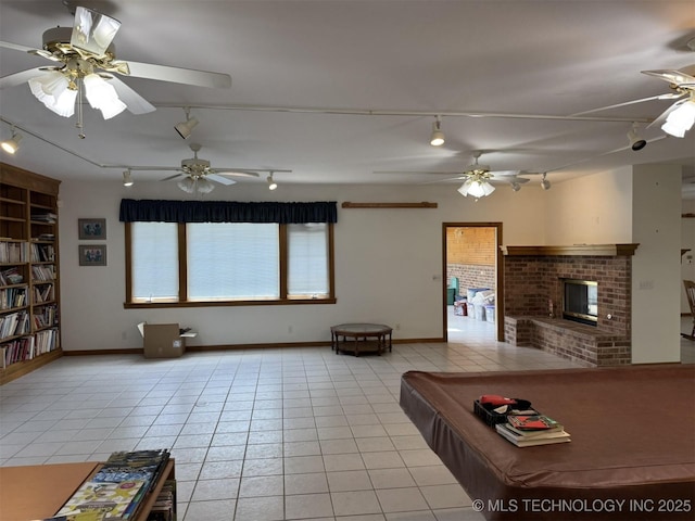 recreation room featuring rail lighting, ceiling fan, and light tile patterned floors