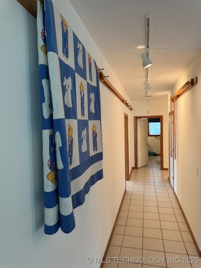 hallway featuring track lighting and light tile patterned floors