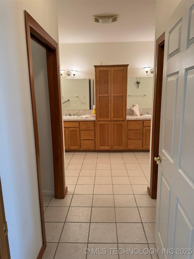 bathroom featuring double vanity, visible vents, and tile patterned floors