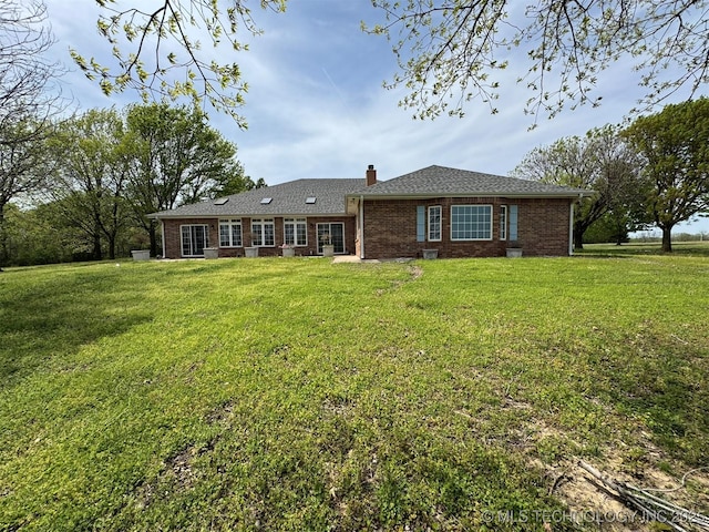 402325 W 2100th Rd, Bartlesville, OK 74006 - back of house with brick siding, a yard, and a chimney