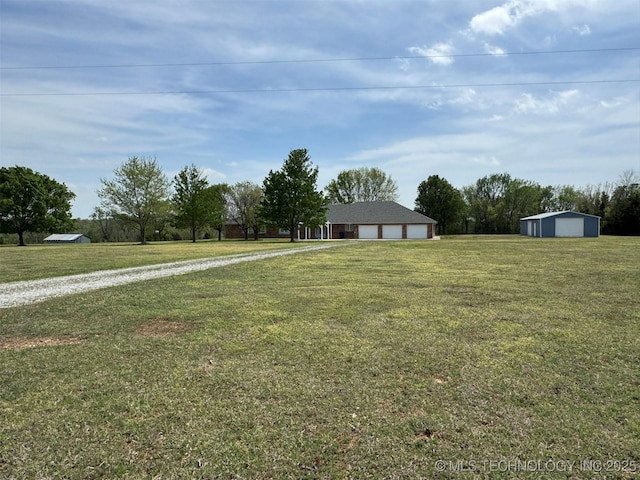 view of yard featuring an outdoor structure and gravel driveway