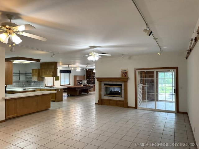 402325 W 2100th Rd, Bartlesville, OK 74006 - living room with track lighting, ceiling fan, a tile fireplace, and baseboards