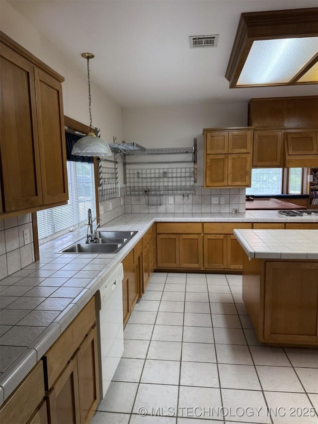 402325 W 2100th Rd, Bartlesville, OK 74006 - kitchen with a sink, tile counters, white dishwasher, decorative backsplash, and light tile patterned floors