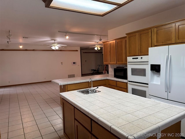 402325 W 2100th Rd, Bartlesville, OK 74006 - kitchen with white appliances, a sink, track lighting, tile countertops, and ceiling fan