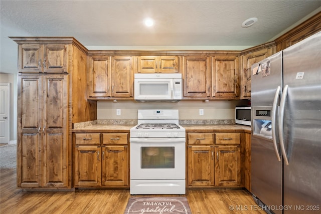 54555 E 340th Rd, Jay, OK 74346 - kitchen featuring brown cabinetry, stainless steel appliances, light wood finished floors, light countertops, and recessed lighting
