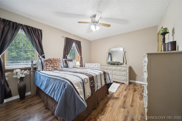 bedroom featuring wood finished floors, a textured ceiling, a ceiling fan, and baseboards
