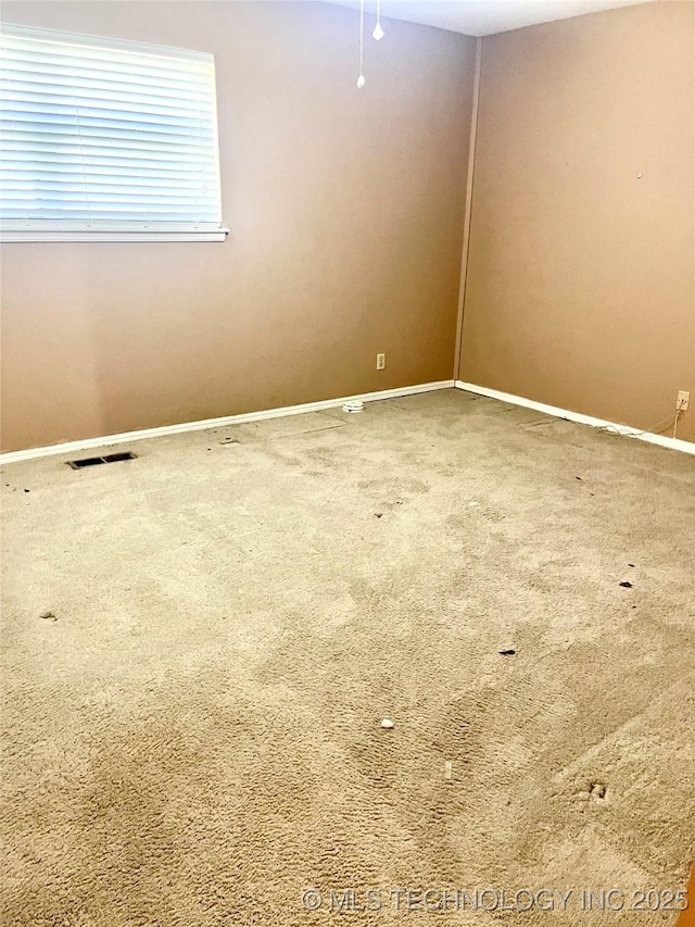 carpeted empty room featuring visible vents and baseboards
