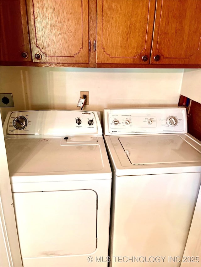 washroom with washer and dryer and cabinet space