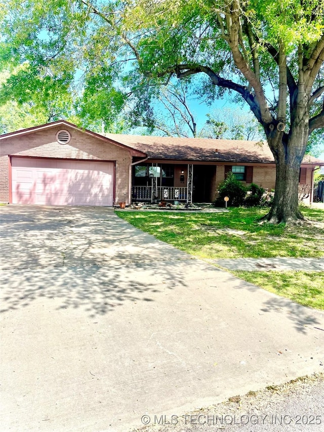 ranch-style home with a front lawn, a porch, concrete driveway, brick siding, and a garage