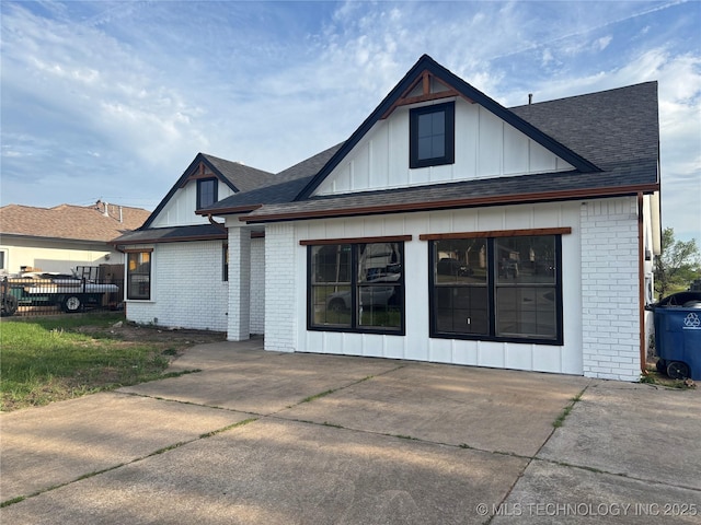 13802 E 19th Pl, Tulsa, OK 74108 - view of front facade featuring brick siding, roof with shingles, and board and batten siding