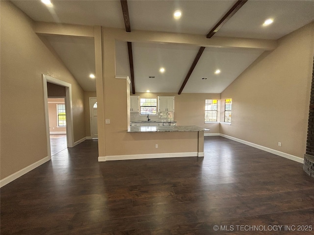 13802 E 19th Pl, Tulsa, OK 74108 - kitchen with white cabinets, a peninsula, vaulted ceiling with beams, and plenty of natural light