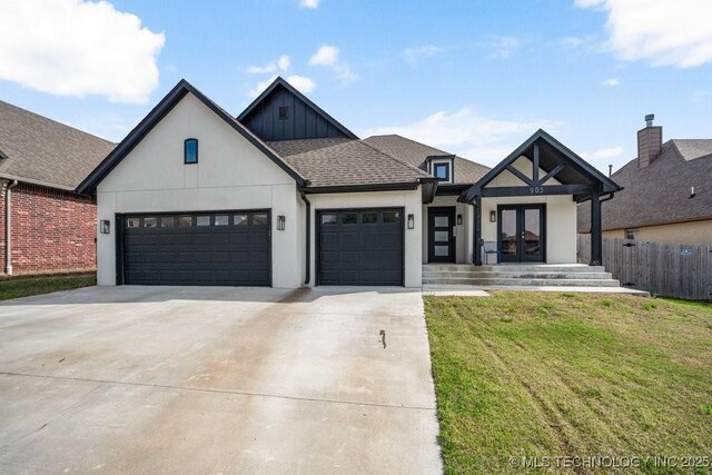 modern inspired farmhouse with driveway, french doors, an attached garage, a front yard, and roof with shingles