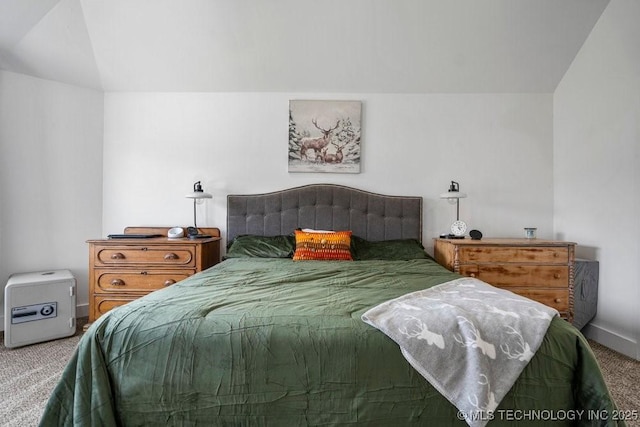 carpeted bedroom with lofted ceiling and baseboards