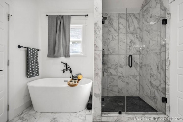 bathroom featuring marble finish floor, a freestanding bath, and a marble finish shower