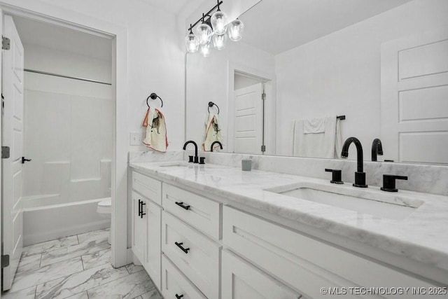 full bathroom with double vanity, marble finish floor, shower / bathtub combination, and a sink