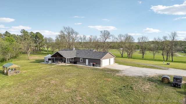 back of house with a lawn and concrete driveway