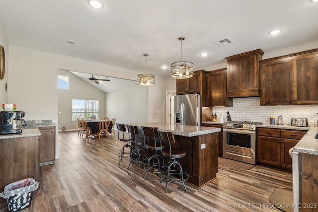 kitchen with ceiling fan, dark wood-style flooring, visible vents, vaulted ceiling, and stainless steel appliances