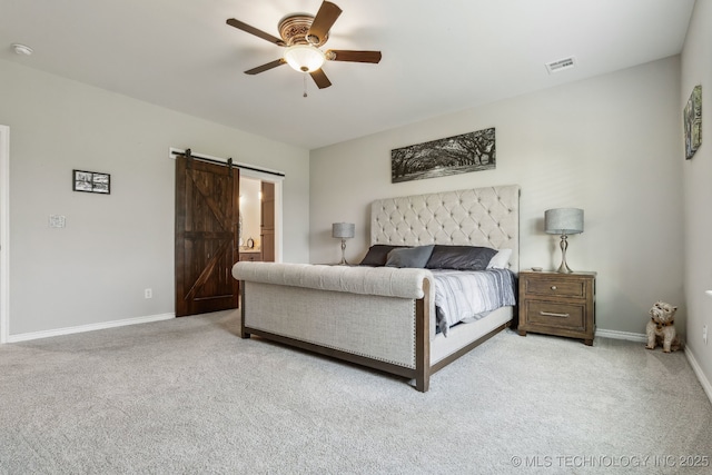 carpeted bedroom with baseboards, a barn door, a ceiling fan, and visible vents