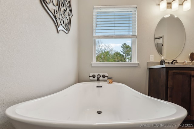 full bath featuring vanity and a soaking tub