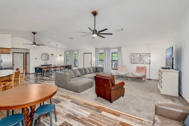 living room with ceiling fan, vaulted ceiling, and visible vents