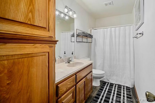 bathroom with toilet, a shower with curtain, vanity, and visible vents