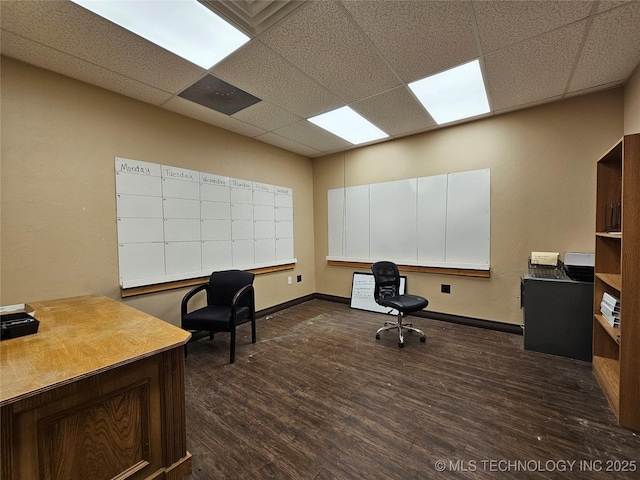 office space with baseboards, dark wood-style floors, and a drop ceiling