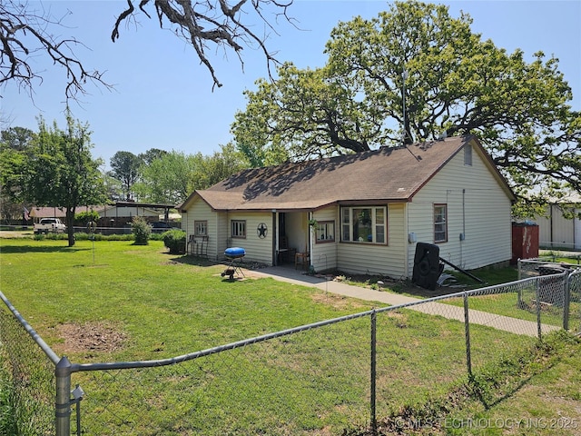 rear view of property with a fenced backyard and a yard
