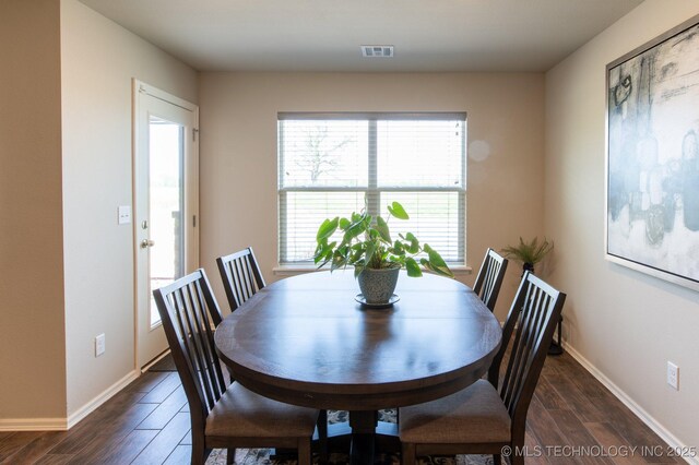 dining room featuring visible vents, baseboards, and dark wood-style flooring