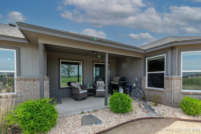 property entrance featuring brick siding, a patio area, and an outdoor living space