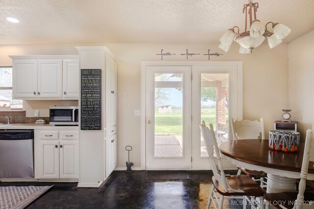 3745 E 420th Rd, Adair, OK 74330 - doorway featuring a chandelier, baseboards, finished concrete floors, and a textured ceiling
